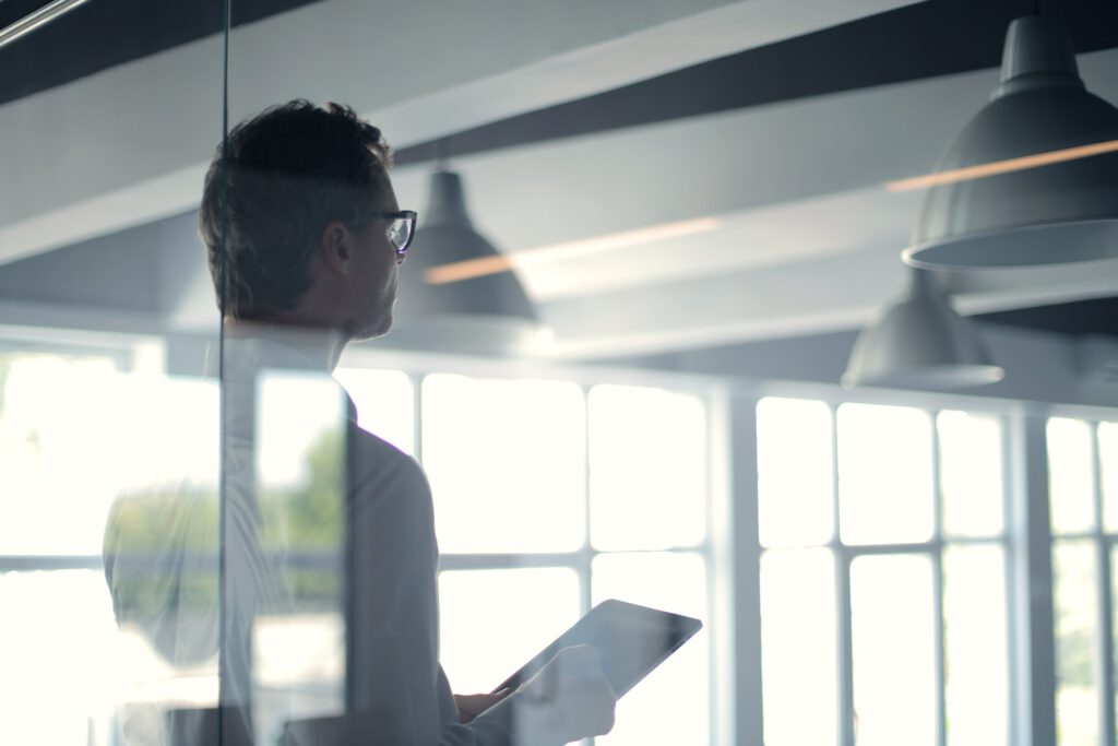 Man met tablet achter glas in kantoor